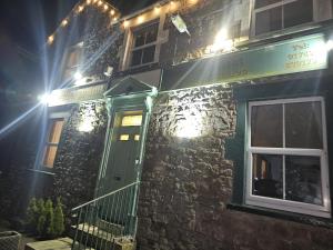 a stone building with a green door at night at Prestleigh Inn in Shepton Mallet