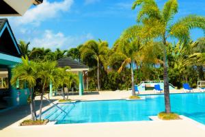 a swimming pool with palm trees in a resort at Prime Location Villa -Sleeps 7 -Private Pool & Gym -Peace & Comfort in Richmond