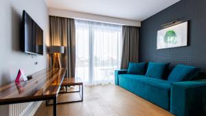 a living room with a blue couch and a table at VacationClub - Baltin Apartament 21 in Mielenko