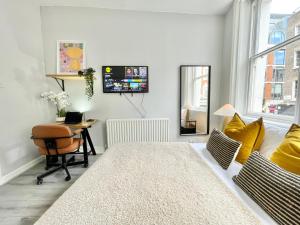 ein Wohnzimmer mit Schreibtisch und Stuhl in der Unterkunft Soho Guest House Room 1 in London