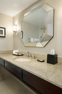 a bathroom with a sink and a large mirror at Sheraton Charlotte Airport in Charlotte