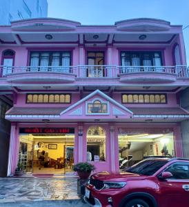 a pink building with a car parked in front of it at Nhat Quynh Hotel in Da Lat