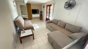 a living room with a couch and a chair at LES GITES DE LA RESERVE in Bouillante