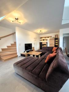 un gran sofá marrón en una sala de estar con escaleras en Winterberg Appartement 21136, en Winterberg
