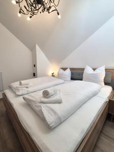 Dos camas en una habitación con sábanas y toallas blancas. en Winterberg Appartement 21136, en Winterberg