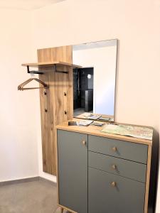 Una cómoda con un espejo encima en Winterberg Appartement 21136, en Winterberg 26 fotos más