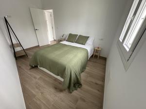 une chambre avec un lit avec une couverture verte dans l'établissement Casa Rural Los Alcornocales - Terraza Chillout, Naturaleza y Comidas al Aire Libre, à Alcalá de los Gazules