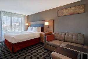 a hotel room with a bed and a couch at TownePlace Suites Las Vegas Airport South in Las Vegas +25 photos