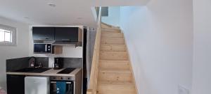 a stairway leading up to a kitchen with a stair case at Au cœur des 3 vallées, appartement avec climatisation in Sainte-Hélène-du-Lac