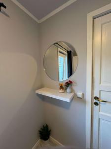 a bathroom with a mirror and a white shelf at cozy room in Tromsø in Tromsø