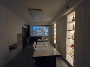 a living room with a table and a television in it at Cloud&Sea Inn in Shenzhen +6 photos