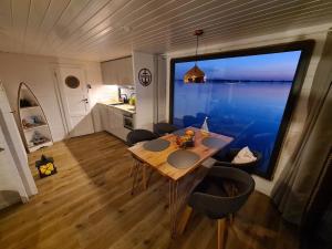 a dining room with a table and a large window at Wasserbungalow Merlin in Lehnin