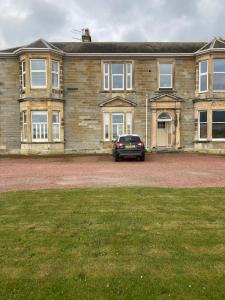 a car parked in front of a large house at The Bunker, Golf Cottage in Prestwick +22 photos