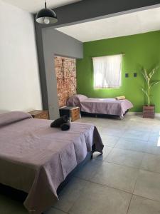 a bedroom with two beds and green walls at The amphitheater house in Villa María