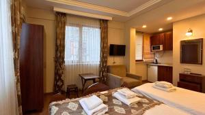 a hotel room with two beds and a kitchen at Capricorn by Otantik Suites in Istanbul