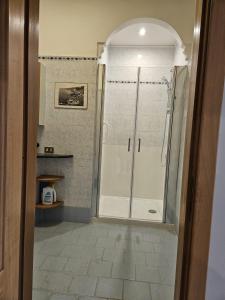 una doccia con una porta in vetro in un bagno di Peter's Flat a Napoli