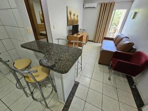 a living room with a table and a couch at Thermas Paradise - Apto de 1 quarto Vista área de lazer - 216 in Rio Quente