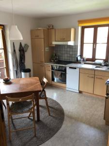 una cucina con un tavolo di legno e una sala da pranzo di Traumhafte Wohnung im Chiemgau a Schneizlreuth Altre 23 foto