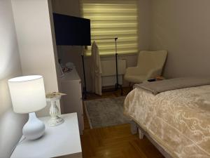 a bedroom with a bed and a table with a lamp at Urban Apartman-privatan parking- in Kraljevo