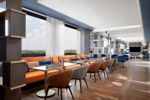 a restaurant with tables and chairs and a large window at Sheraton Milan San Siro in Milan