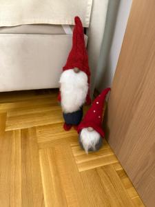 a santa claus toy sitting on the floor next to a bed at Urban Apartman-privatan parking- in Kraljevo