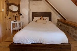 a bedroom with a white bed in a attic at La Maison Renaud 1813 - 5 chambres - 12 personnes in Saint-Férréol-les-Neiges
