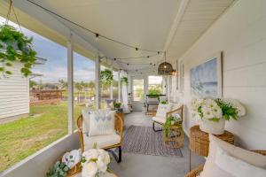 プンタ・ゴーダにあるDock and Lanai Waterfront Punta Gorda Cottageの籐椅子と花の入ったポーチ