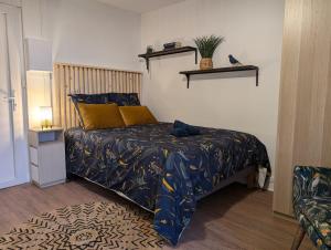 Un dormitorio con una cama con almohadas azules y amarillas. en L'Exotic - Studio Centre-Ville, en Niort
