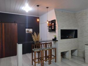 - un salon avec un bar et une cheminée dans l'établissement Apto Térreo em Tramandaí, à Tramandaí