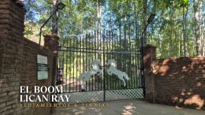 a black iron gate with three white horses on it at El Boom Lican Ray - Alojamientos & Tinajas in Licán Ray