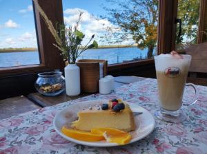 a piece of cake on a table with a drink at Karczma Rybna Rybaczówka Marina B&B in Świnoujście