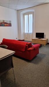 ein Wohnzimmer mit einem roten Sofa und einem TV in der Unterkunft Apartments Cabianchi in Orta San Giulio