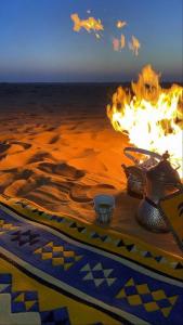 un tavolo con un vaso e un fuoco sulla spiaggia di Waha a Ismant