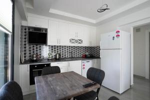 Una cocina con una mesa y un refrigerador blanco. en MSD Konakları, en Muğla 3 fotos más