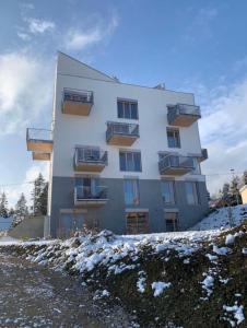 a building on a hill with snow on the ground at PanorámaX12 Hillside apartmán in Dolný Kubín