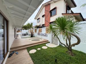 a house with a palm tree in the yard at Villa Paapa & Maama Luxurious Private Pool in Johor Bahru