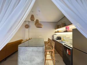 a kitchen with a counter with chairs and a table at Villa Paapa & Maama Luxurious Private Pool in Johor Bahru