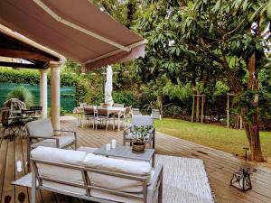 a patio with a couch and a table and chairs at Villa dans un puits de verdure avec piscine résidentielle in Valbonne
