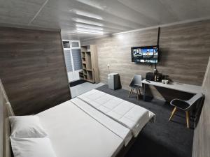 a bedroom with a bed and a desk and a tv at The Mini-hotel on Mukanov St in Almaty
