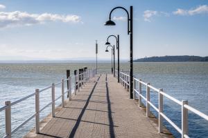 a pier with street lights on the water at Passignano Lake Apartment in Passignano sul Trasimeno