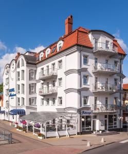 un gran edificio blanco con techo rojo en Hotel Marina en Międzyzdroje