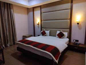 GangānagarHotel Vikramaditya的一间位于酒店客房内的带大床的卧室