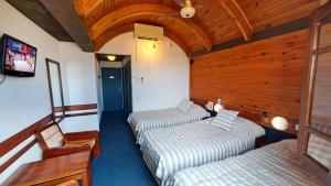 a room with two beds and a tv in it at Hosteria Querandi in Villa Gesell