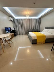 ein Schlafzimmer mit einem Bett, einem Tisch und einer Couch in der Unterkunft Guestroom 2 -3rd flr Barretto, Olongapo near beach in Olongapo