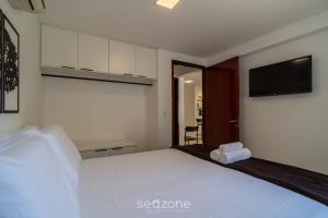 a bedroom with a large white bed and a television at Apto em cond quadra mar e c/ piscina HSS0007 in Tambaú +17 photos