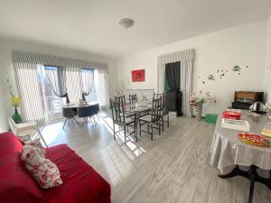 a living room with a red couch and a table at Affittacamere La Dolce Mela in Francavilla di Sicilia