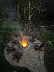 a fire pit with chairs and a group of flames at The Coop NEW A-frame Hot Tub, Fire Pit, Loft in Flat Rock