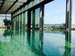 a large building with a pool of water with windows at Graffit Gallery Design Hotel in Varna City