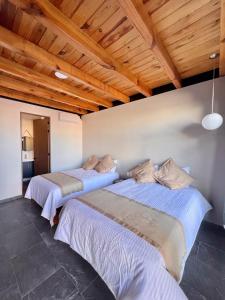 Dos camas en una habitación con techos de madera. en Gran Casa Xalisco, en Guadalajara 67 fotos más