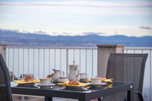 a table with cups and plates of food on it at Apartman Klaudia in Ika